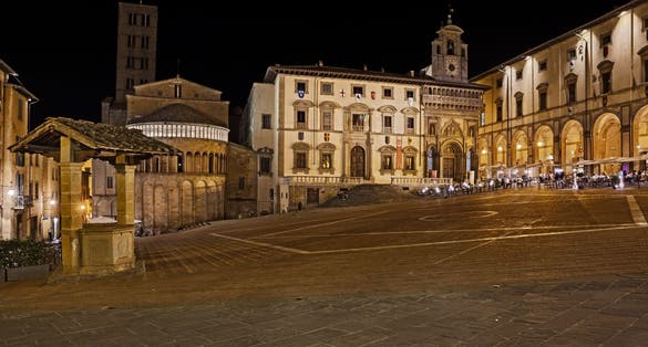 photo of view of Arezzo, Tuscany, Italy: night view of the main square Piazza Grande, with the medieval church and buildingsArezzo, Italy.