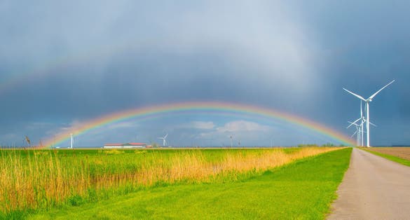 Dark sky and a rainbow over a rural landscape, Almere, Flevoland, The Netherlands.