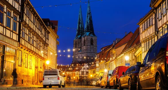 photo of view of Charming Quedlinburg town evening street view illuminated with Christmas lights old St. Nicholas Church St. Nicholas Kirche background historical half-timbered houses facade. Festive city German