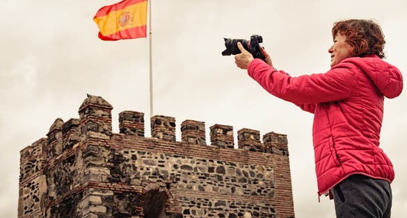 photo of tourist woman with camera taking travel picture on Sohail Castle in Fuengirola, Malaga Spain.