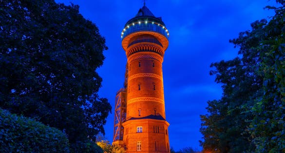 Photo of Illuminated historical water tower in Mülheim Ruhr at night.