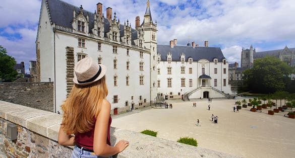 Tourist girl visiting the Château des ducs de Bretagne a large castle in the city of Nantes, France
