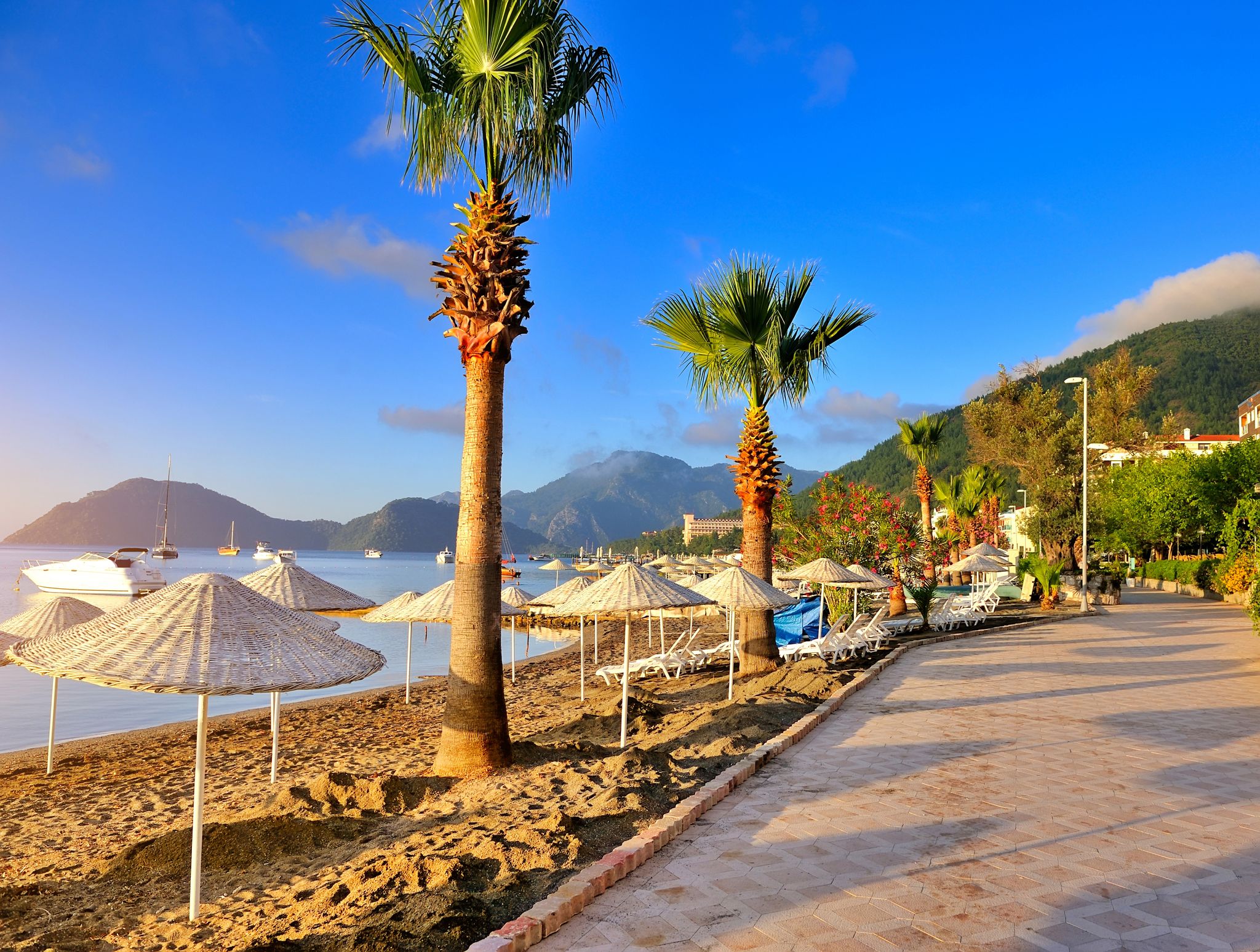 Photo of seafront against the backdrop of the picturesque bay of blue sea and mountains, Marmaris, Turkey.