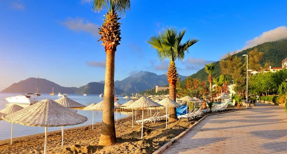 Photo of seafront against the backdrop of the picturesque bay of blue sea and mountains, Marmaris, Turkey.