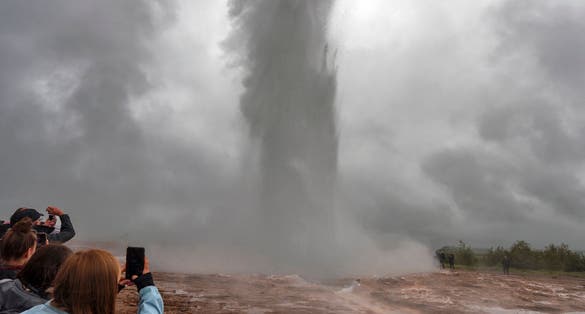 photo of geysir, Iceland. People recording the great geysir eruption in southwestern Iceland.