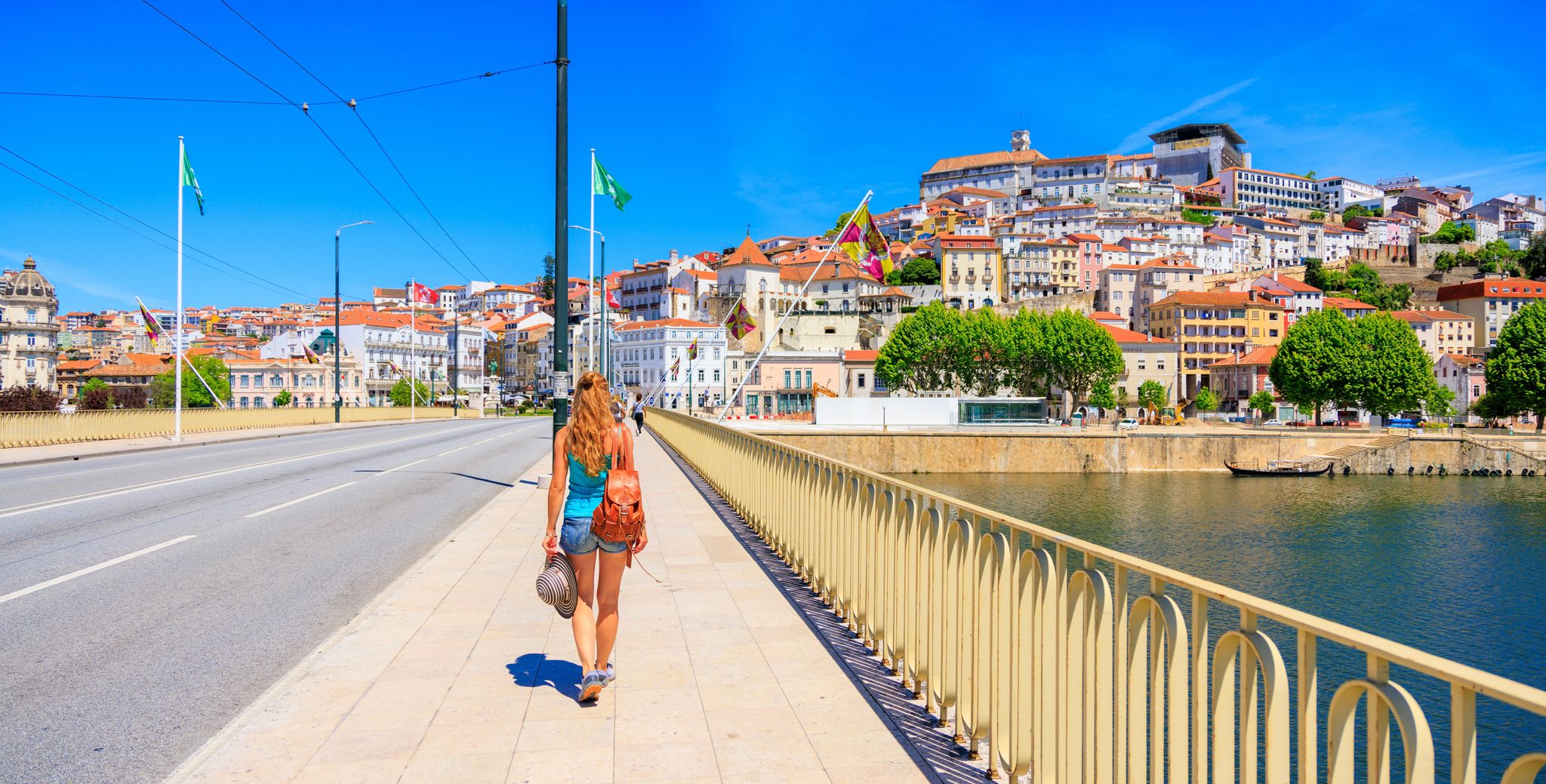 Woman tourist walking in the bridge to Coimbra in Portugal
