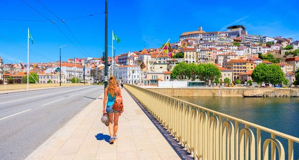 Woman tourist walking in the bridge to Coimbra in Portugal