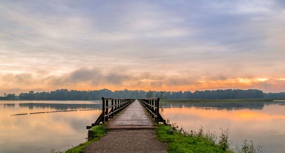 Early morning at sunrise by the lake Sirvena in Birzai - the longest wooden bridge in Lithuania