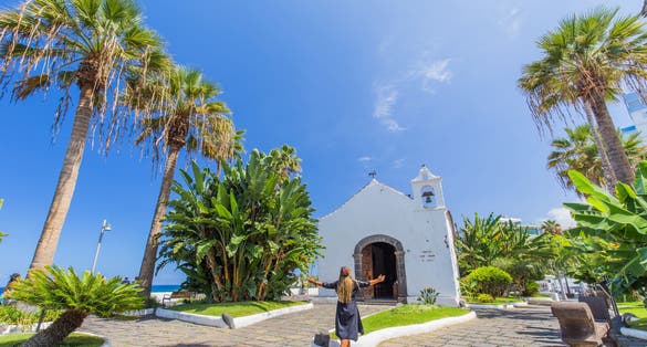 photo of a woman enjoying the beautiful views at Lago Martiánez in Puerto de la Cruz, Tenerife, Canary Islands, Spain.