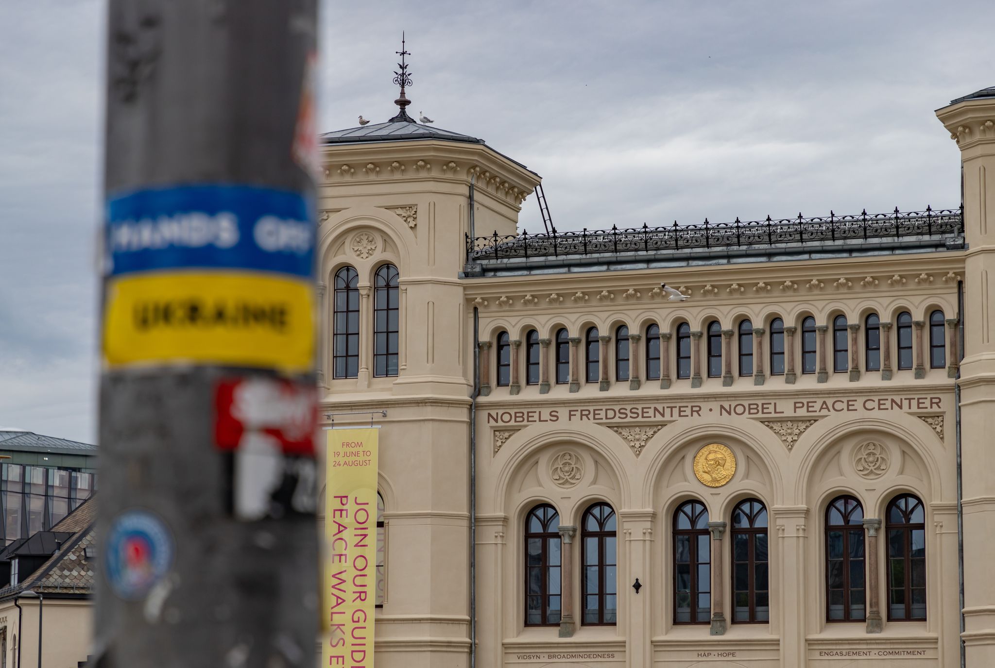 A picture of the Nobel Peace Center and a blurred Hands Off Ukraine sticker on the foreground.