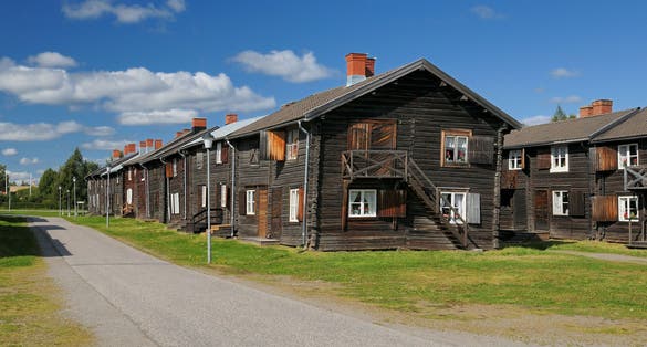 photo of wooden houses of Church Town Bonnstan on a sunny summer day with a few clouds in the sky in Skellefteå, Sweden.