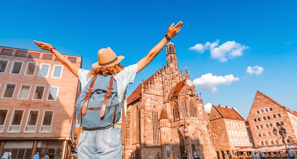 Photo of girl tourist enjoying a warm summer day on the main square of Nuremberg during sunset. 