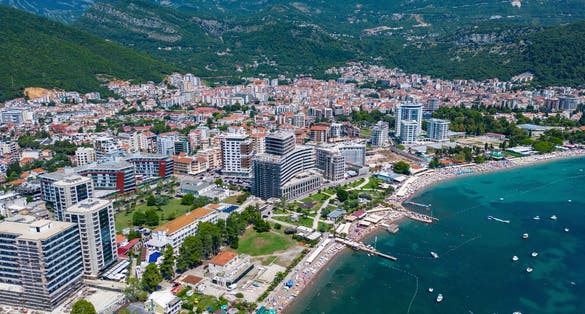 City of Budva in Montenegro. Aerial view of Port and Beach Greco. Coastline of the Adriatic Sea at summer time. Natural landscapes of Montenegro. Balkans. Europe.