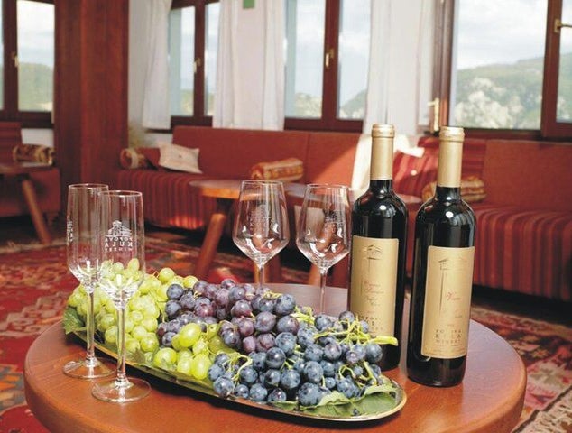 A cozy setting at Kartal Winery with bottles of wine, fresh grapes, and wine glasses on a wooden table..jpg