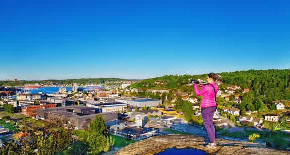 Woman with a photocamera early in the morning on a mount in Sandefjord. Norway