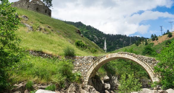 Photo of arch bridge with minaret in the old Greek church. Giresun ,Turkey.