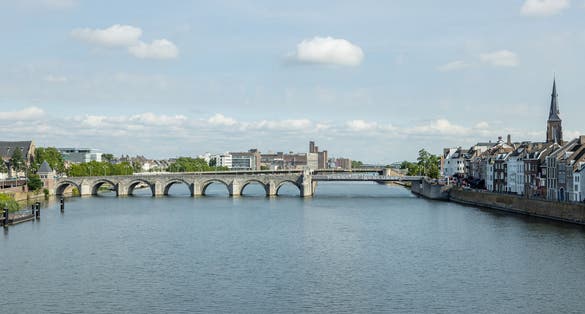photo of aerial view of the Maas river with the Saint Servatius Bridge (Sint Servaasbrug) and an urban landscape in the background, sunny summer day with a blue sky in Maastricht, Netherlands.