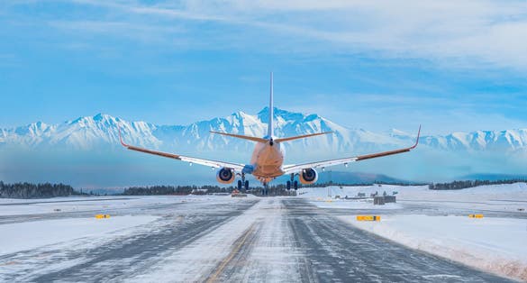 Photo of White passenger airplane landing on snowy airport - Oslo, Norway.
