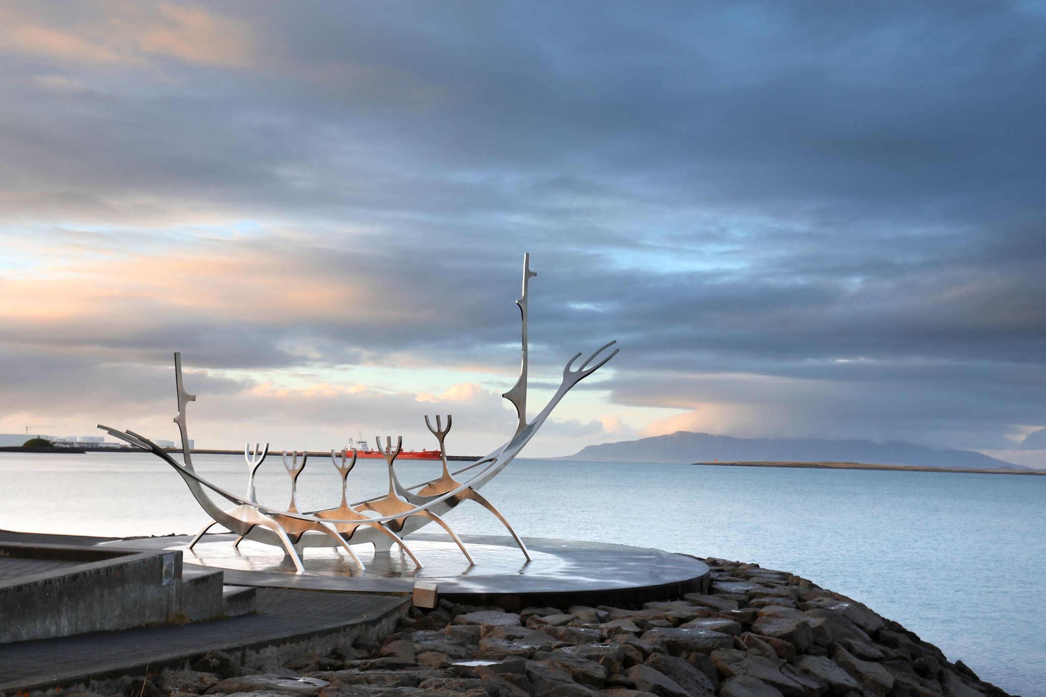photo of sun voyager monument, clouds, landmark of Reykjavik city.