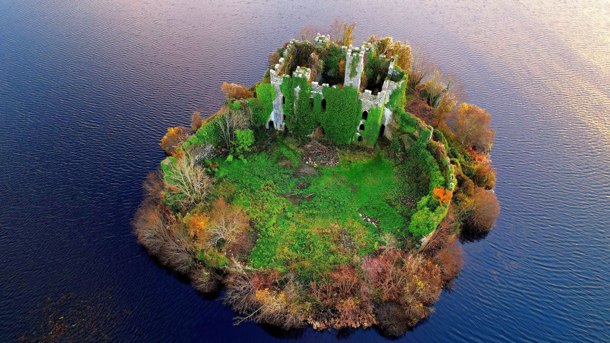 photo of view of An aerial of the McDermott's Castle and a national monument surrounded by tranquil sea, Cork, Irland.