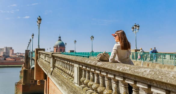 Photo of tourist woman in French ancient town Toulouse and Garonne river, France.
