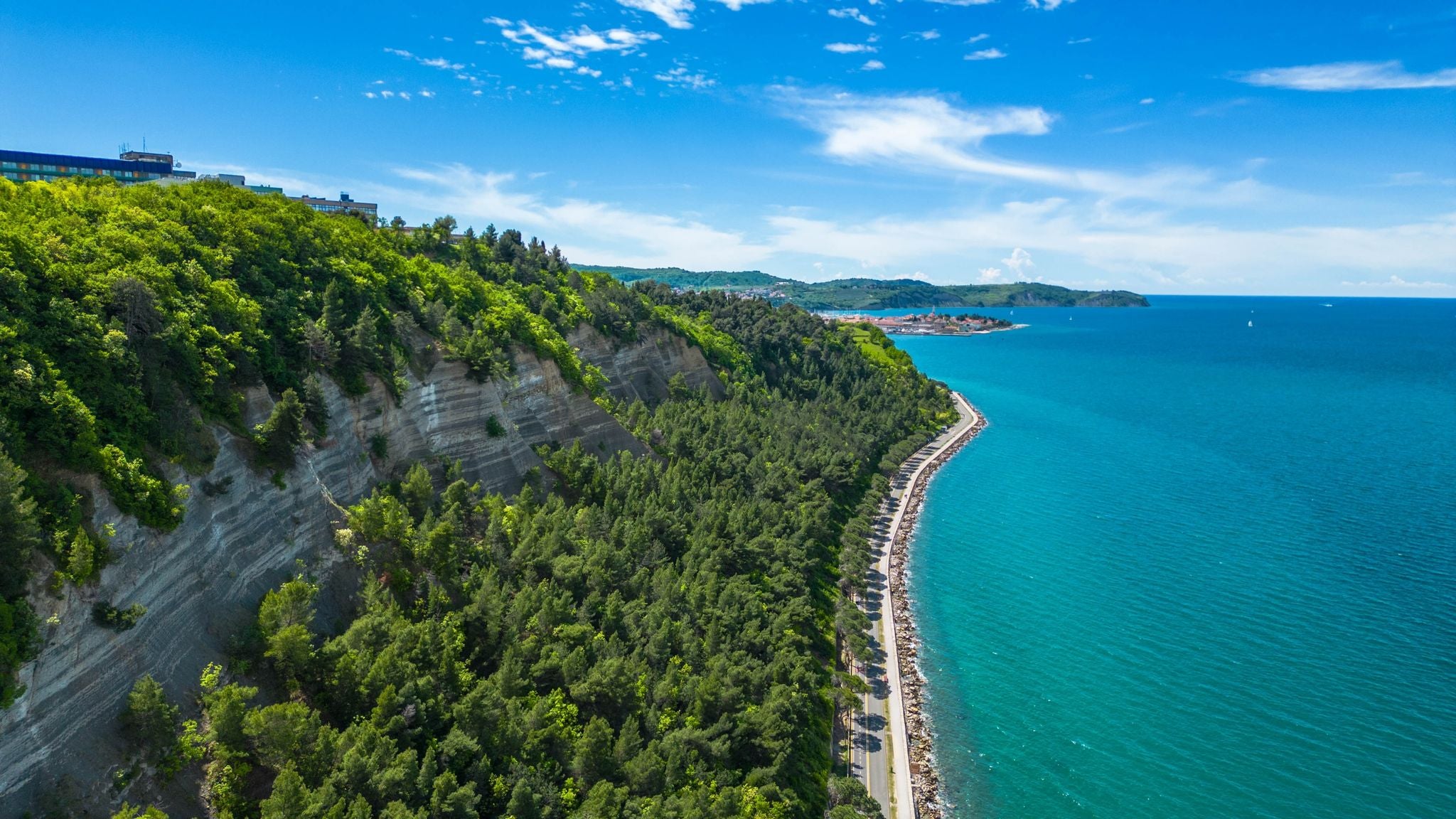 The scenic road between Koper and Izola along the sea coast in Slovenia offers a delightful route for cycling or leisurely walks with breathtaking views of the Adriatic Sea captured by drone