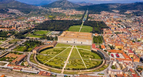 Aerial view of the Royal Palace of Caserta also known as Reggia di Caserta. It is a former royal residence with large gardens in Caserta, near Naples, Italy. The historic center of the city is nearby.