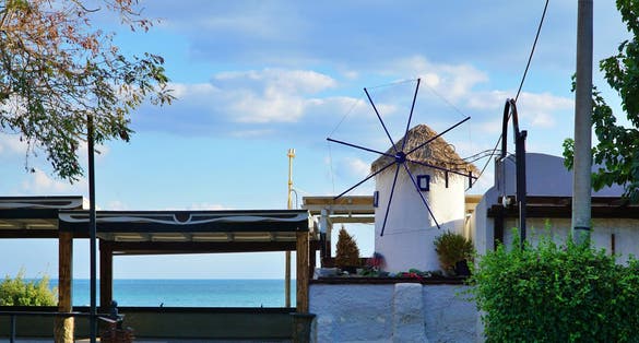 Photo of view of a windmill on the coastline in Alexandroupoli, Greece..