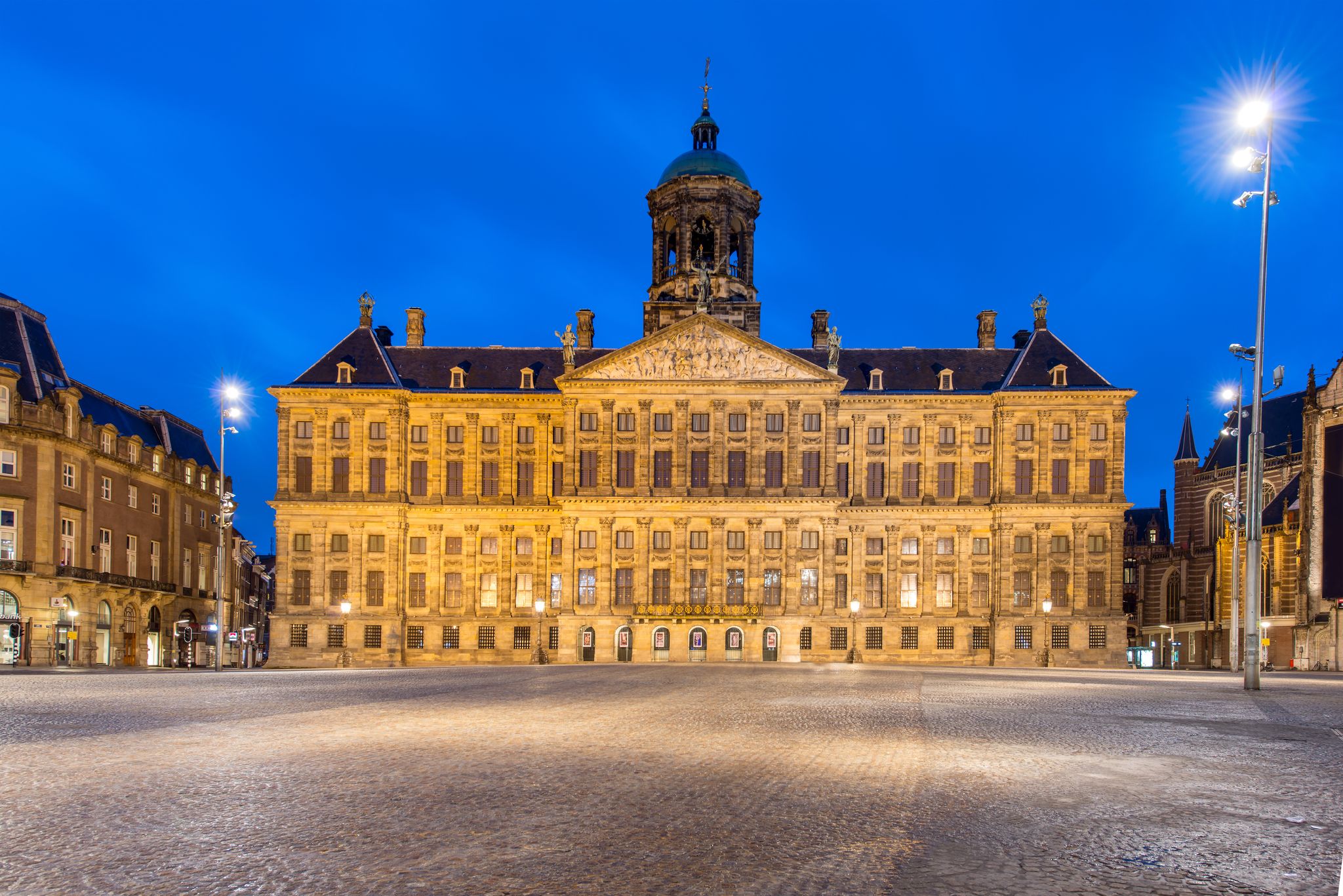 Photo of Royal Palace at the Dam Square at night in Amsterdam, Netherlands.