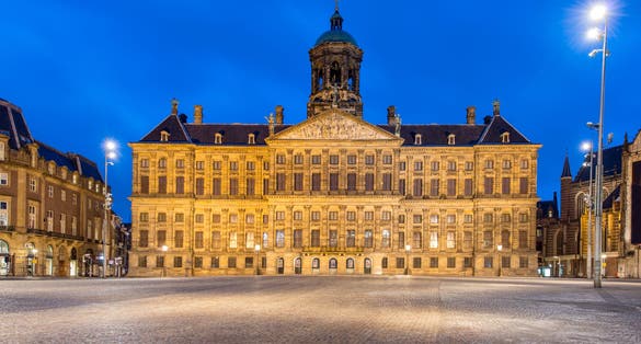 Photo of Royal Palace at the Dam Square at night in Amsterdam, Netherlands.
