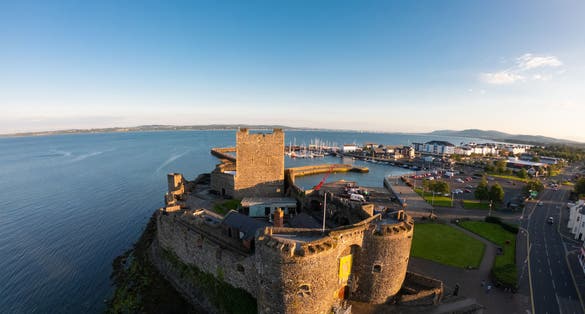 Carrickfergus Castle and Marina on Background Aerial view. Coastal Route in Northern Ireland.
