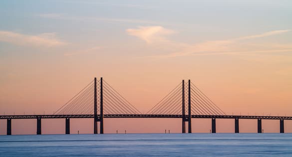 The Oresund Bridge is a combined motorway and railway bridge between Sweden and Denmark (Malmo and Copenhagen). Long exposure. Selective focus.