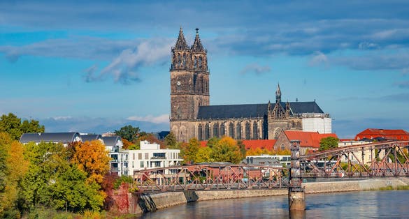 View over Magdeburg historical downtown, Elbe river, city park and the ancient medieval cathedral in golden Autumn colors at blue cloudy sky and sunny day, Magdeburg, Germany