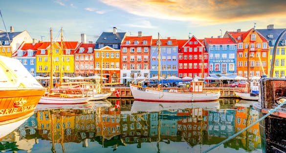 Photo of scenic summer view of Nyhavn pier with colorful buildings and boats in Old Town of Copenhagen, Denmark.