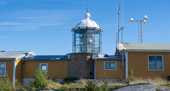 photo of view of Bjuroklubb lighthouse a national cultural heritage south of Skellefteå Sweden is an old lighthouse with a Fresnel lens which can be seen in the center of the image, the beacon is inactive.