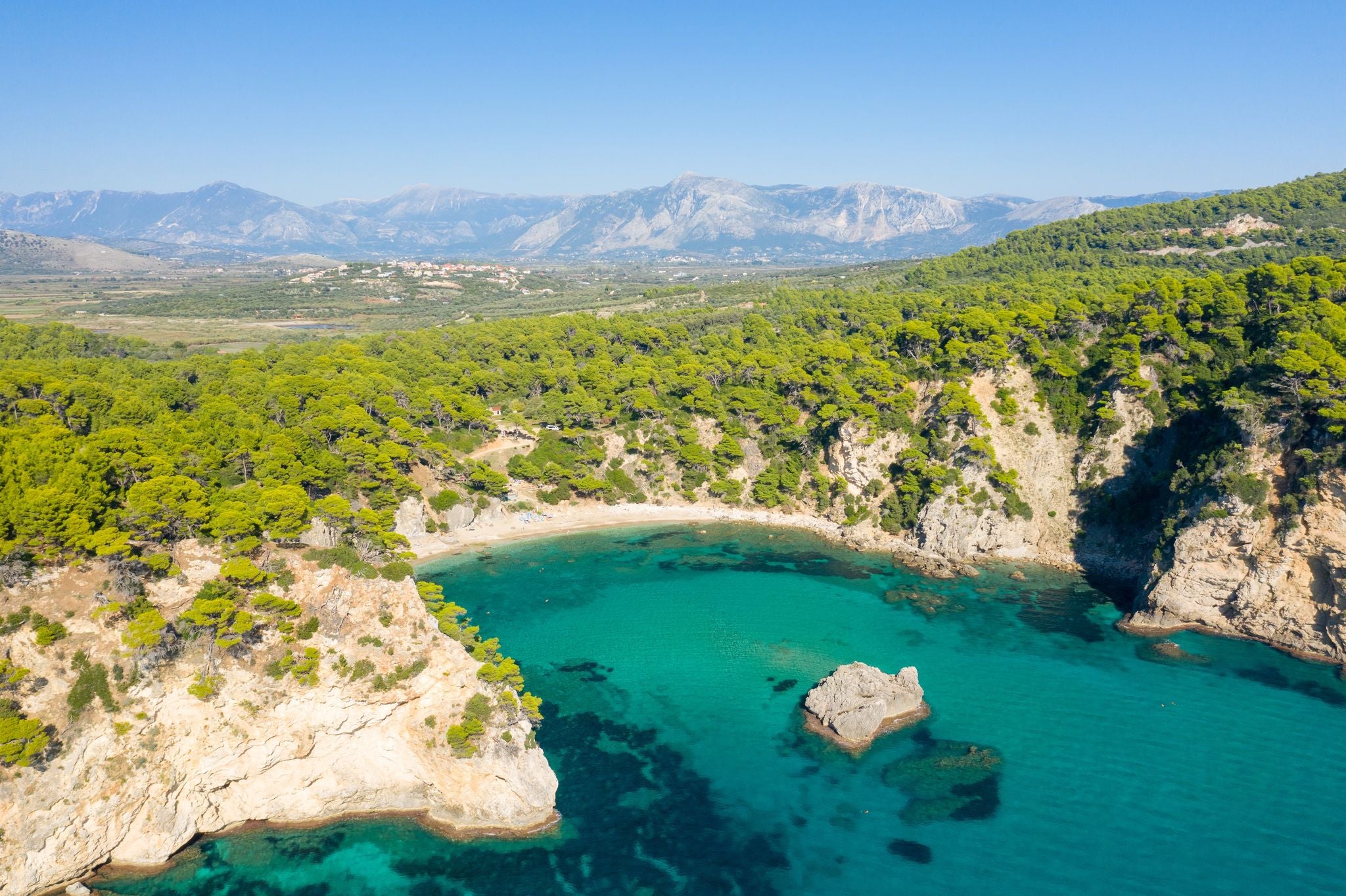 photo of Alonaki Fanariou sandy beach and its green rocky cliffs , in Europe, Greece, Epirus, towards Igoumenitsa, by the Ionian sea, in summer, on a sunny day.