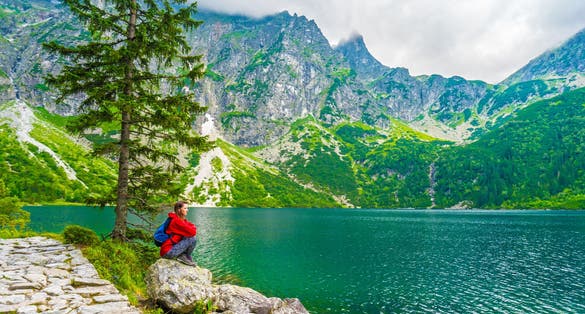 Beautiful Woman in Red Jacket Enjoying Scenic Mountain Lake View in Zakopane, Poland