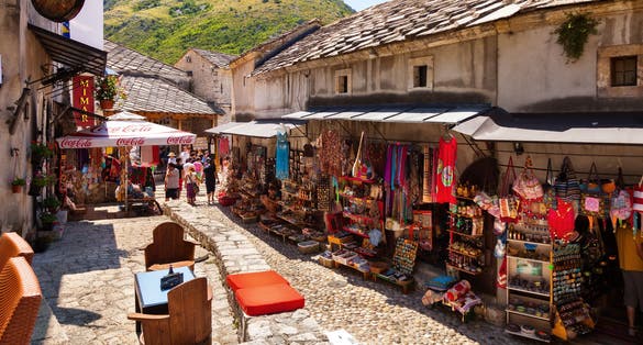 People walking through the Old Town with many shops and cafes in Mostar, Bosnia and Herzegovina. Mostar is situated on the Neretva River.