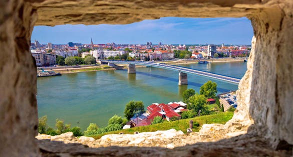 Photo of city Of Novi Sad and Danube river aerial view through stone window from Petrovaradin, Vojvodina region of Serbia.