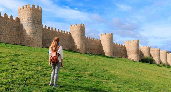 photo of view of Woman tourist enjoying view of Avila surrounding wall in Spain- Castile and Leon.