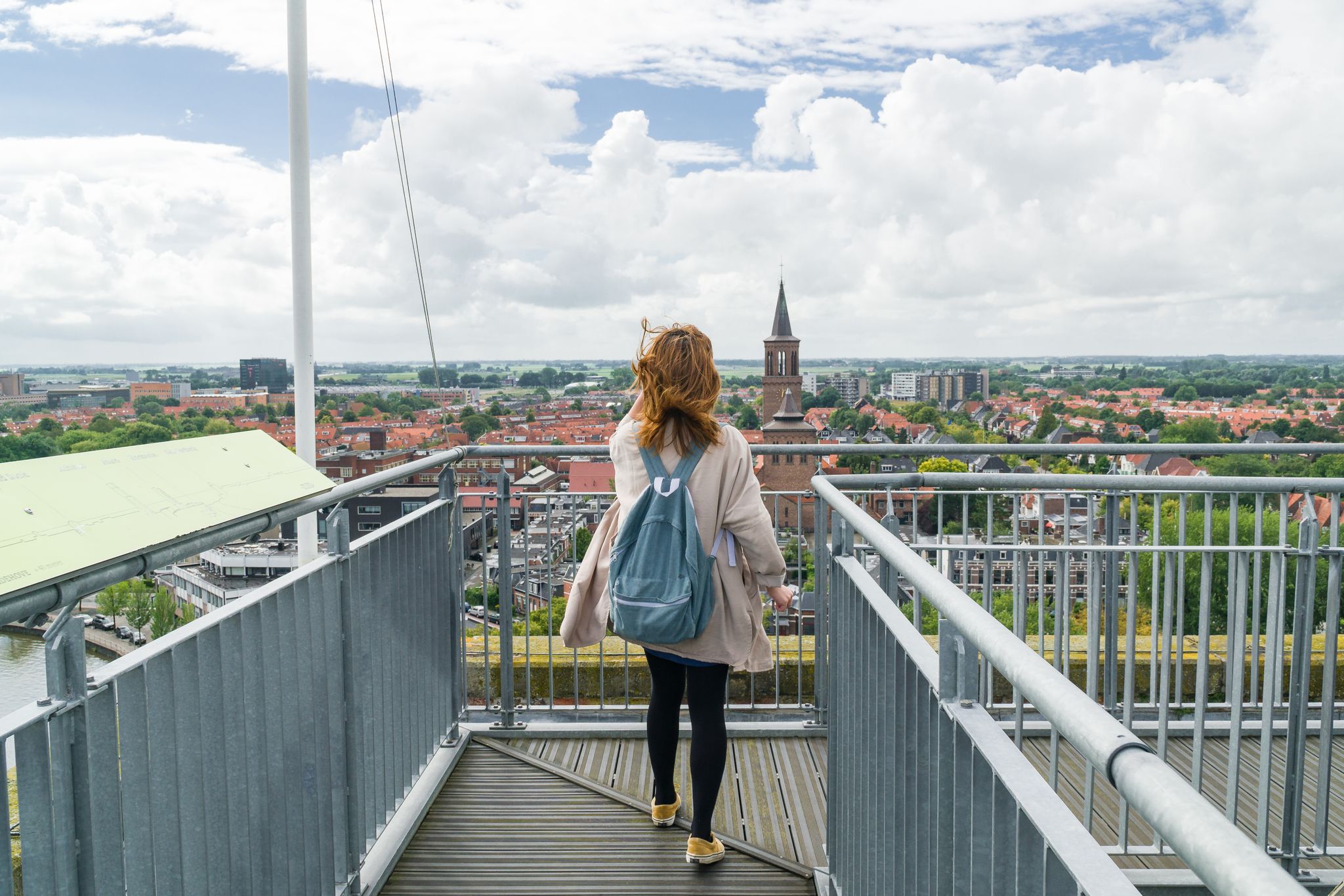 photo of girl standing on roof of the Oldehove over looking the city Leeuwarden, the Netherlands.