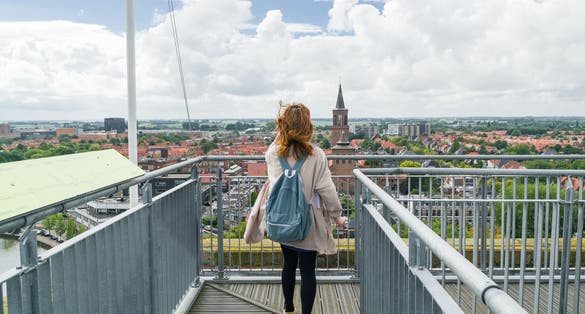 photo of girl standing on roof of the Oldehove over looking the city Leeuwarden, the Netherlands.