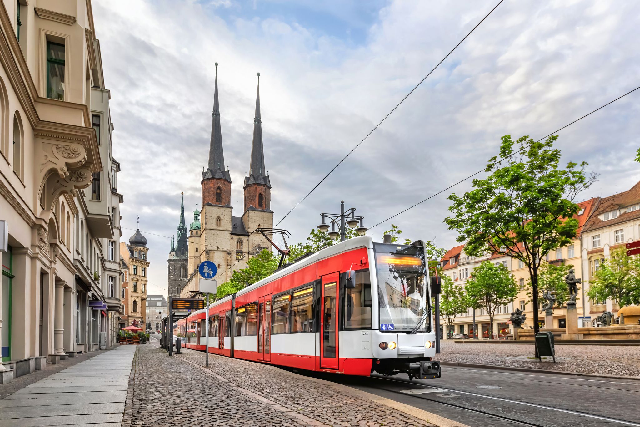 photo of view of Halle (Saale), Germany. Red tram going on Hallmarkt square in front of Marktkirche church in old town
