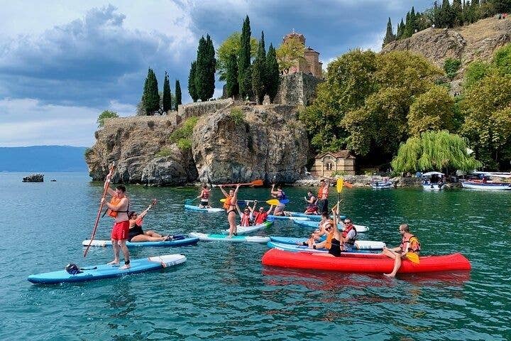 People paddleboarding and kayaking on Lake Ohrid in North Macedonia, near the Church of St. John at Kaneo..jpg