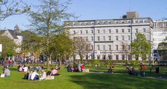 People talking and resting in Eyre Square Park, Galway, Ireland