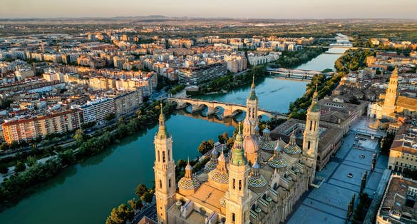 photo of  view of Spectacular Zaragoza city skyline at sunset. View of old town center, Cathedral of Zaragoza and Ebro River. Medieval and historic travel destination in Aragon - Spain. Sunset point, orange reflections