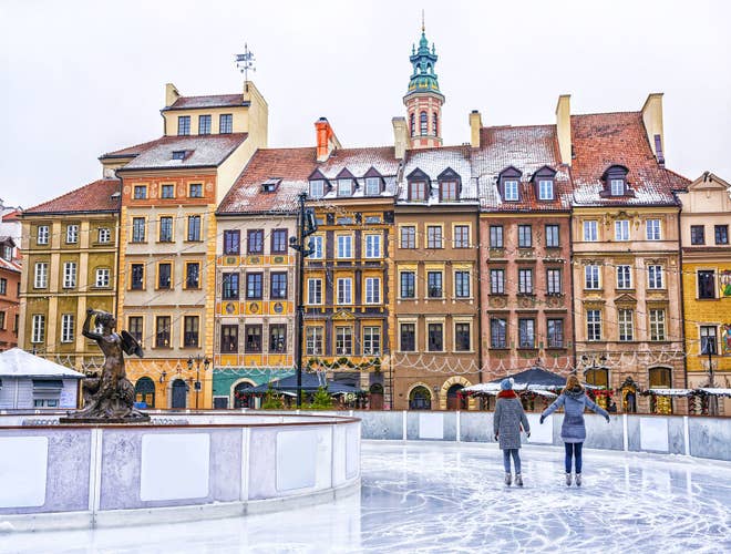 Two girls skate on a skating rink in the Old town square in Warsaw.jpg