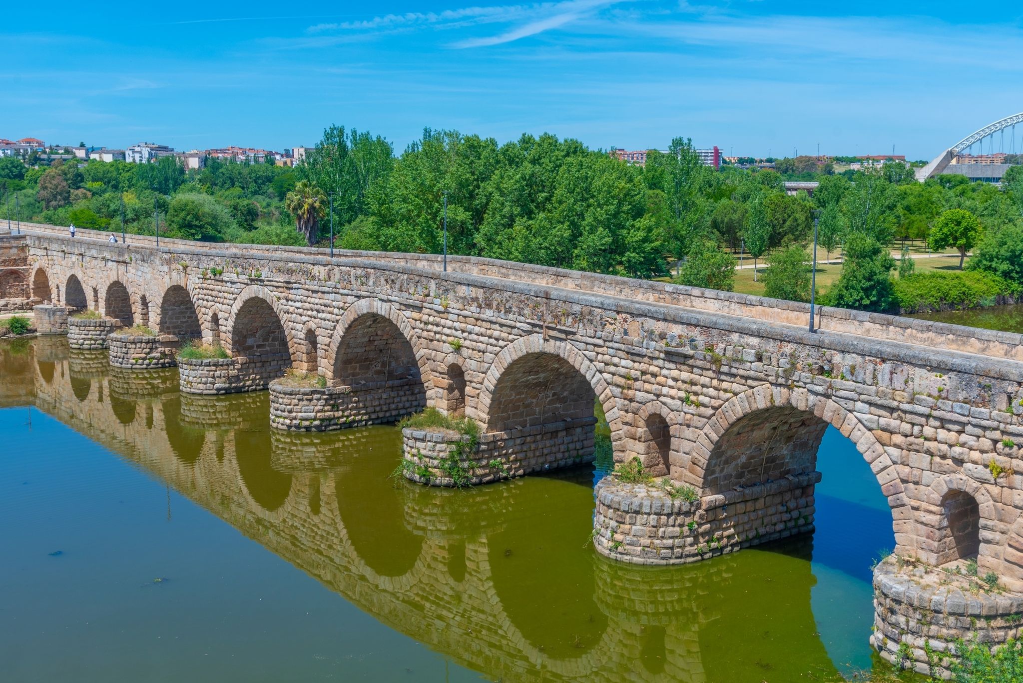 photo of view of Historical Bridge, built by the Romans. It is the longest surviving Roman bridge, over the Guadiana River in Merida, Extremadura, Spain. Puente Romano is the Spanish name for the Roman Bridge.