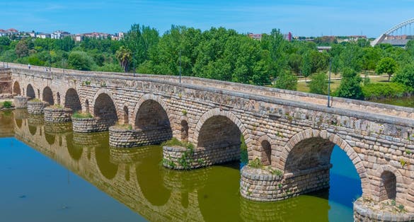 photo of view of Historical Bridge, built by the Romans. It is the longest surviving Roman bridge, over the Guadiana River in Merida, Extremadura, Spain. Puente Romano is the Spanish name for the Roman Bridge.