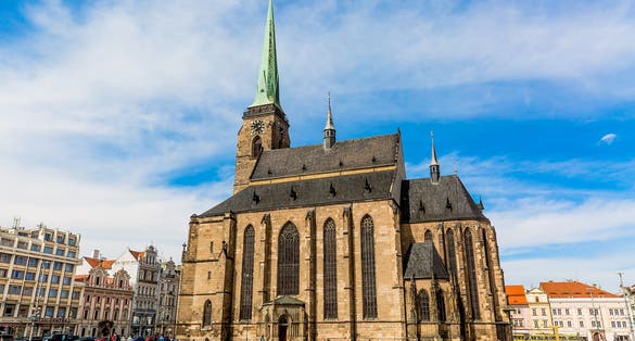 Photo of St. Bartholomew's Cathedral in the main square of Plzen with blue sky and clouds in sunny day, Czech Republic.